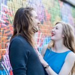 Couple laughing in front of colourful street art in Shoreditch