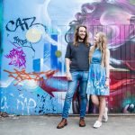Couple in front of blue and pink street art on Brick Lane