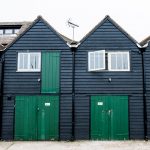 Black fish huts with green doors on Whitstable seafront