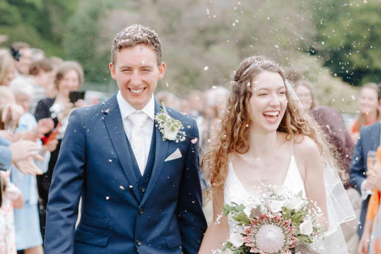Bride and groom getting showered with confetti