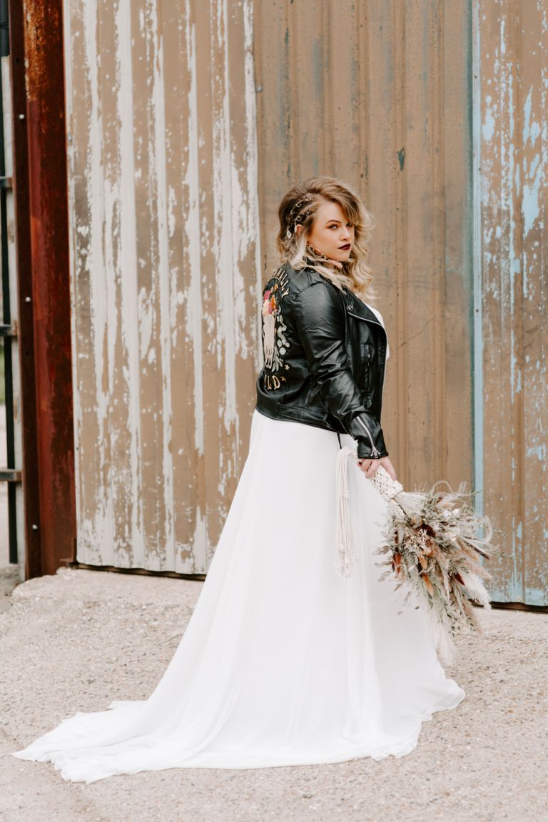 Bride wearing leather jacket at Barns at Lodge Farm