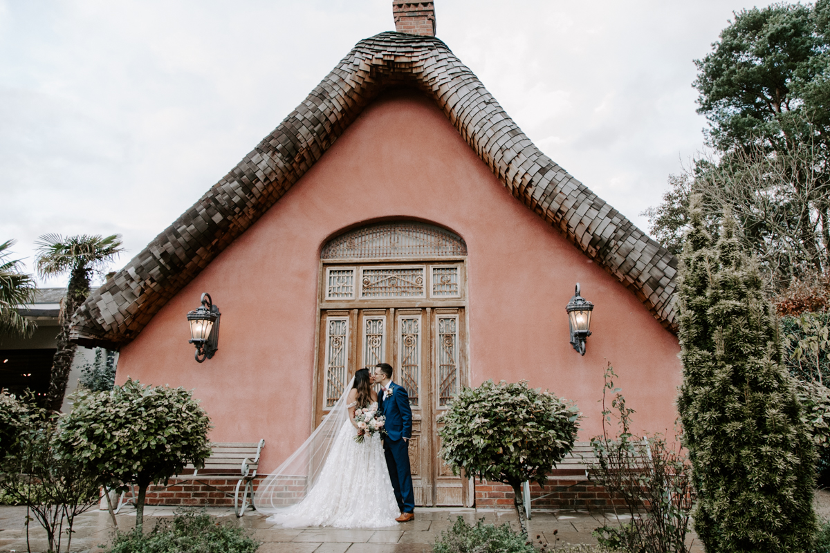 Bride and groom stood in front of Le Petit Chateau wedding venue chapel